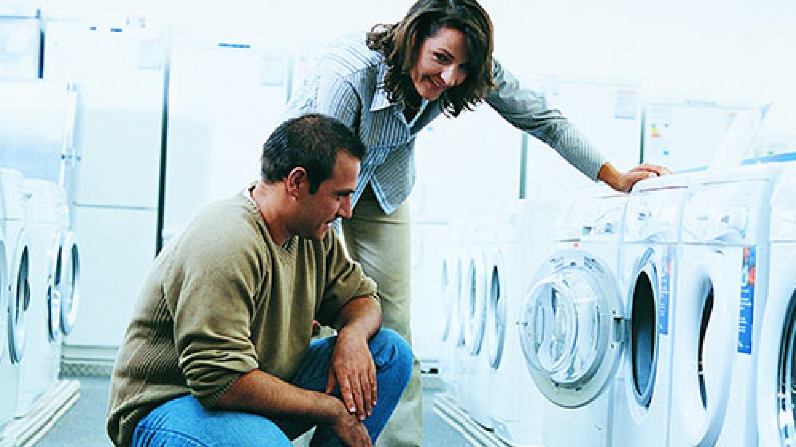 Couple looking at clothes washer in appliance store