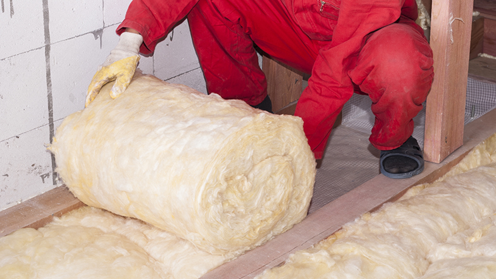 Person rolling out insulation