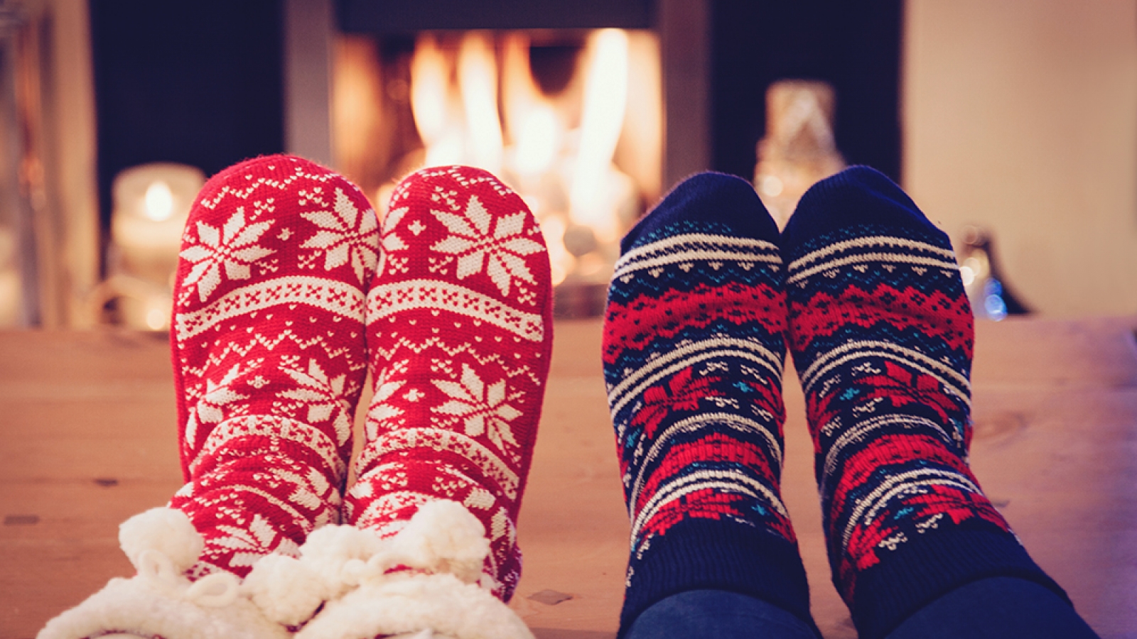 People wearing cozy socks in front of a fire