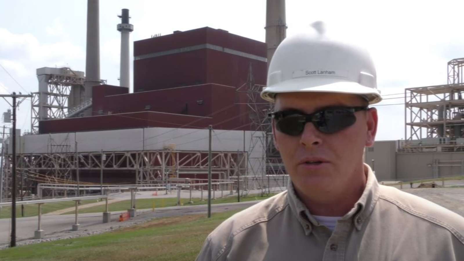 employee who served in the military speaking in front of a power plant
