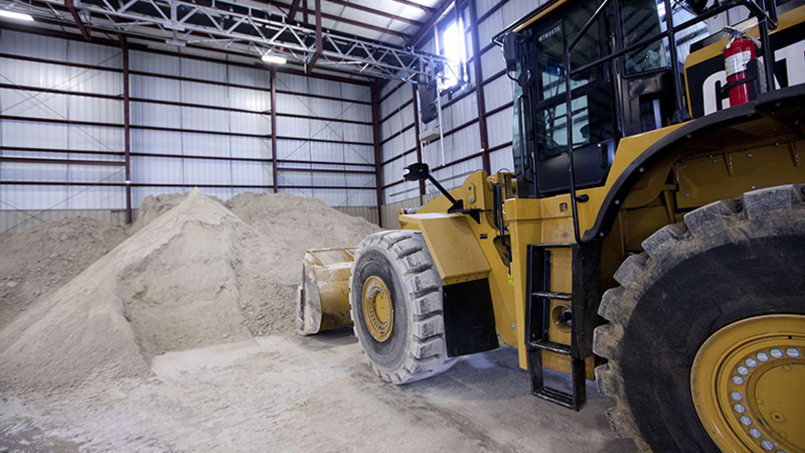 front loader scooping gypsum inside a warehouse