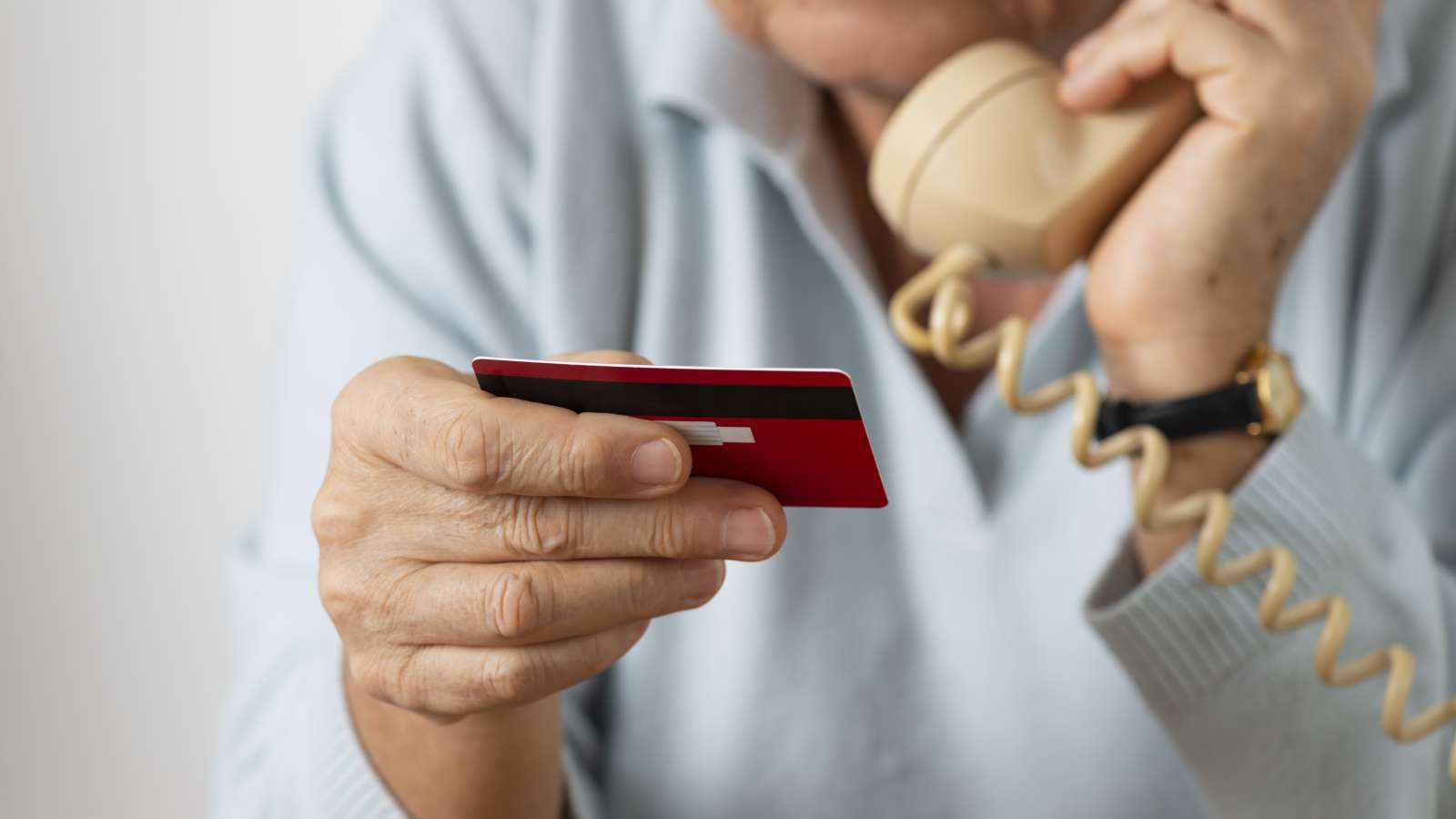 person on a phone holding a credit card
