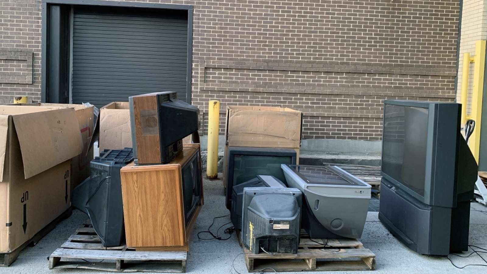televisions on pallets at a loading dock at a recycling event