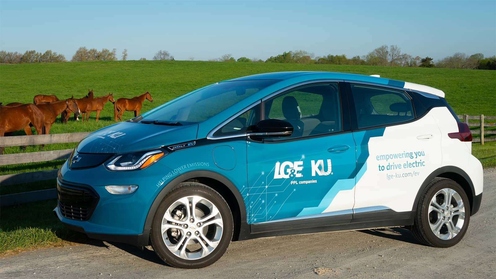 electric vehicle in front of horse pasture