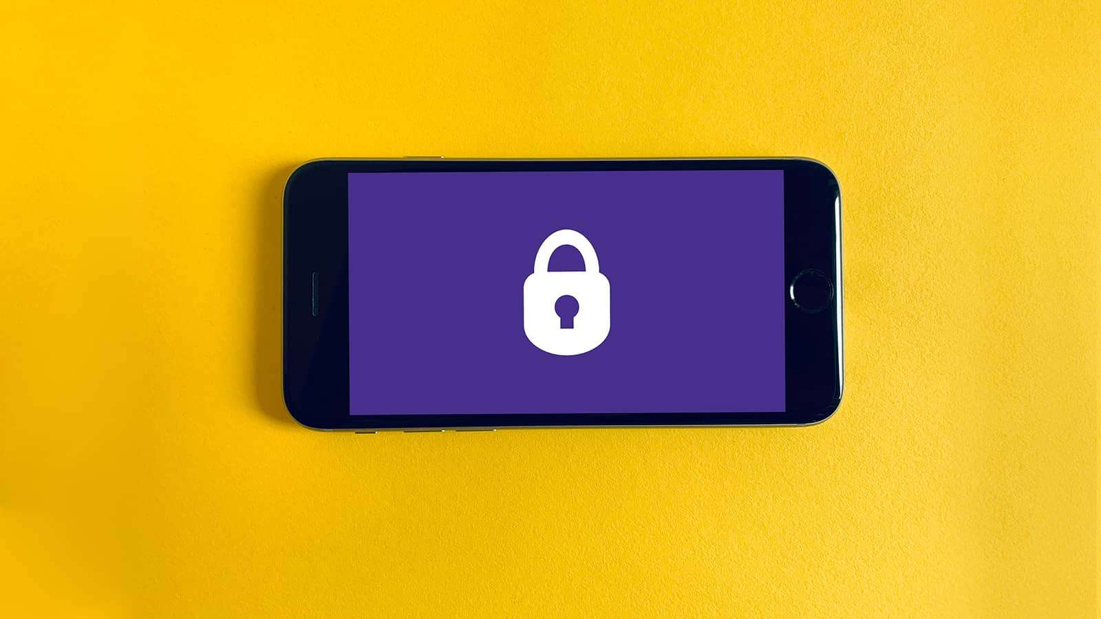 mobile phone on yellow background with lock on screen