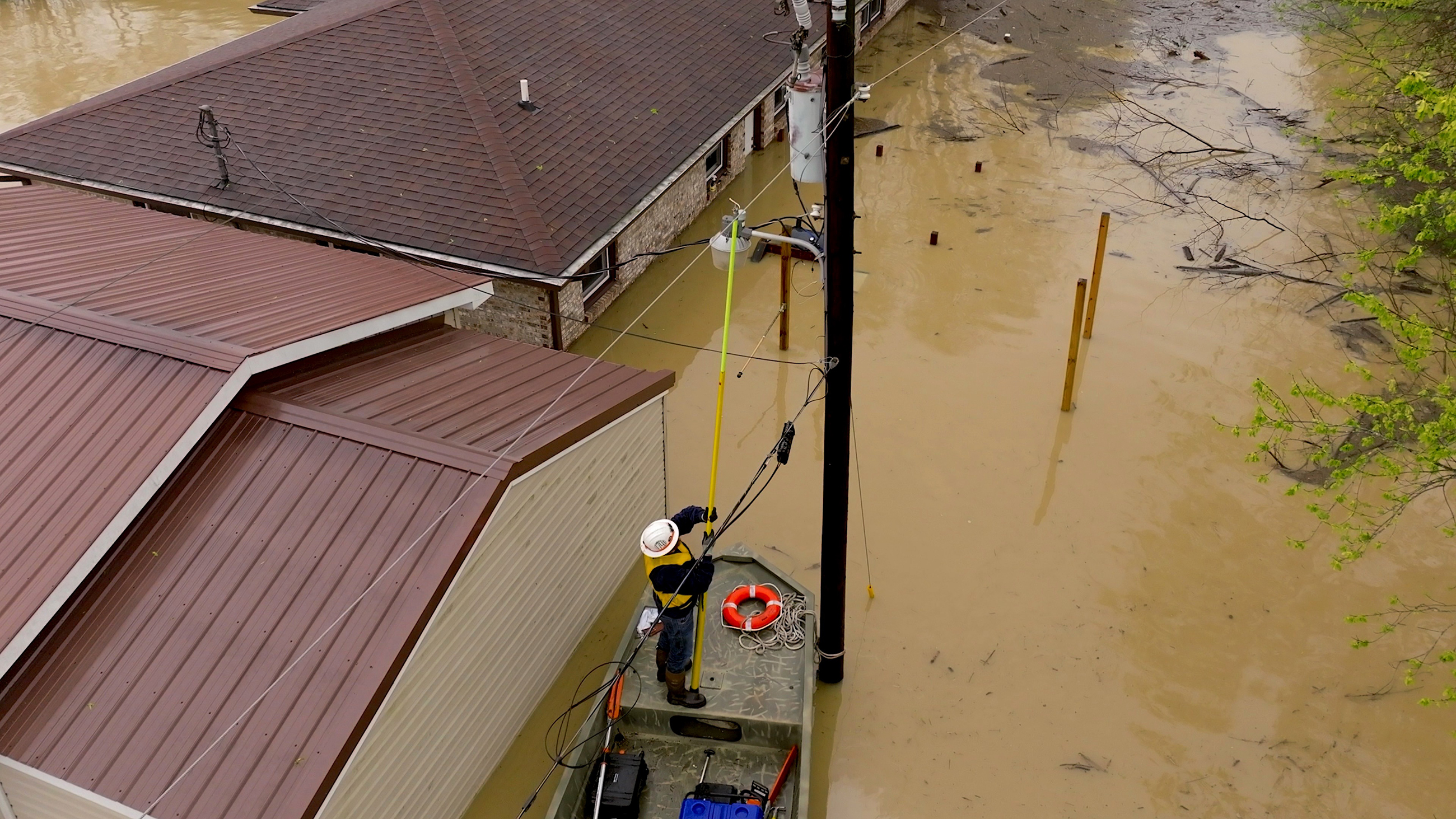 line technician restoring power to a line in flood waters