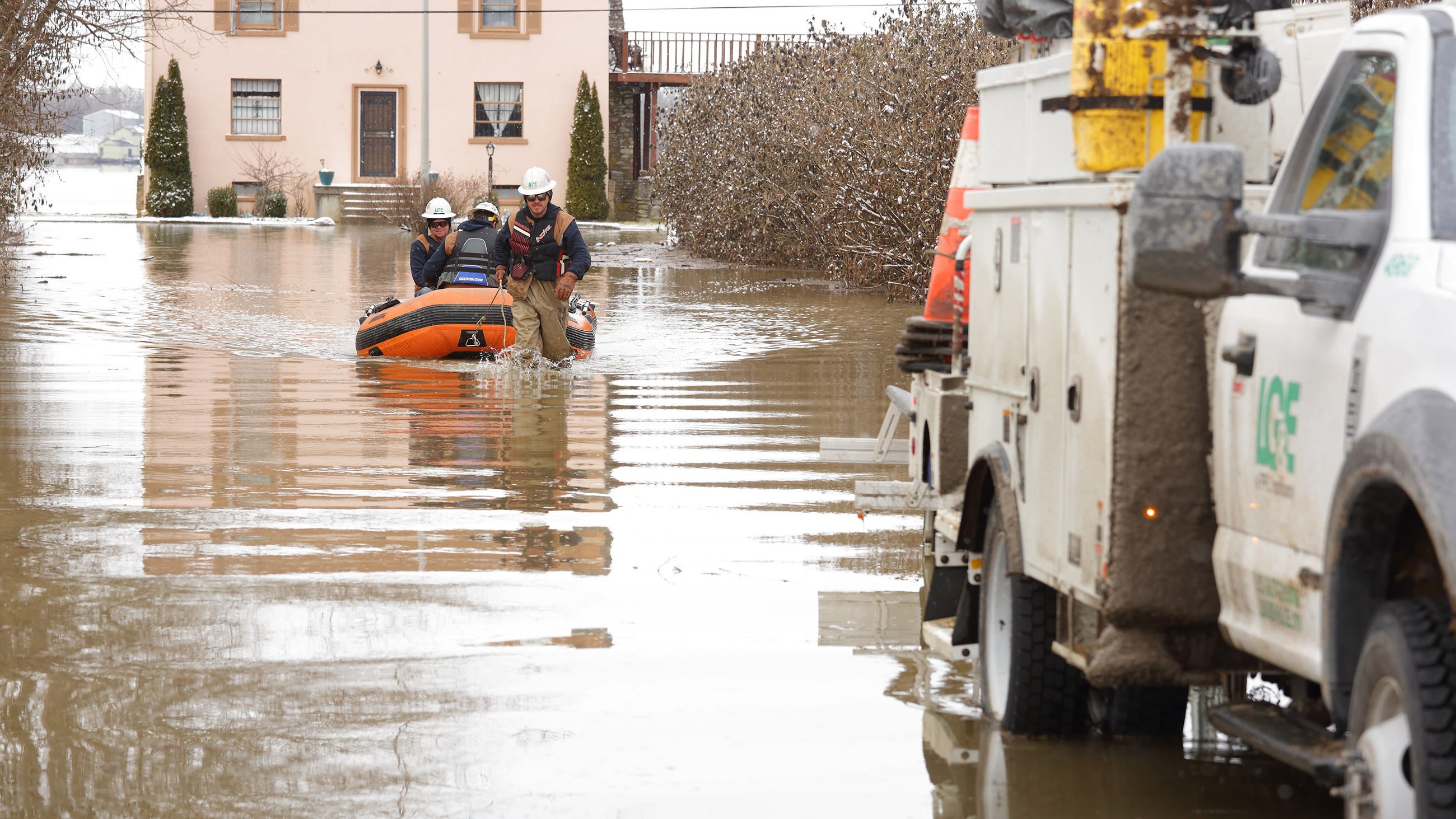 line technicians pulling boat from flood waters