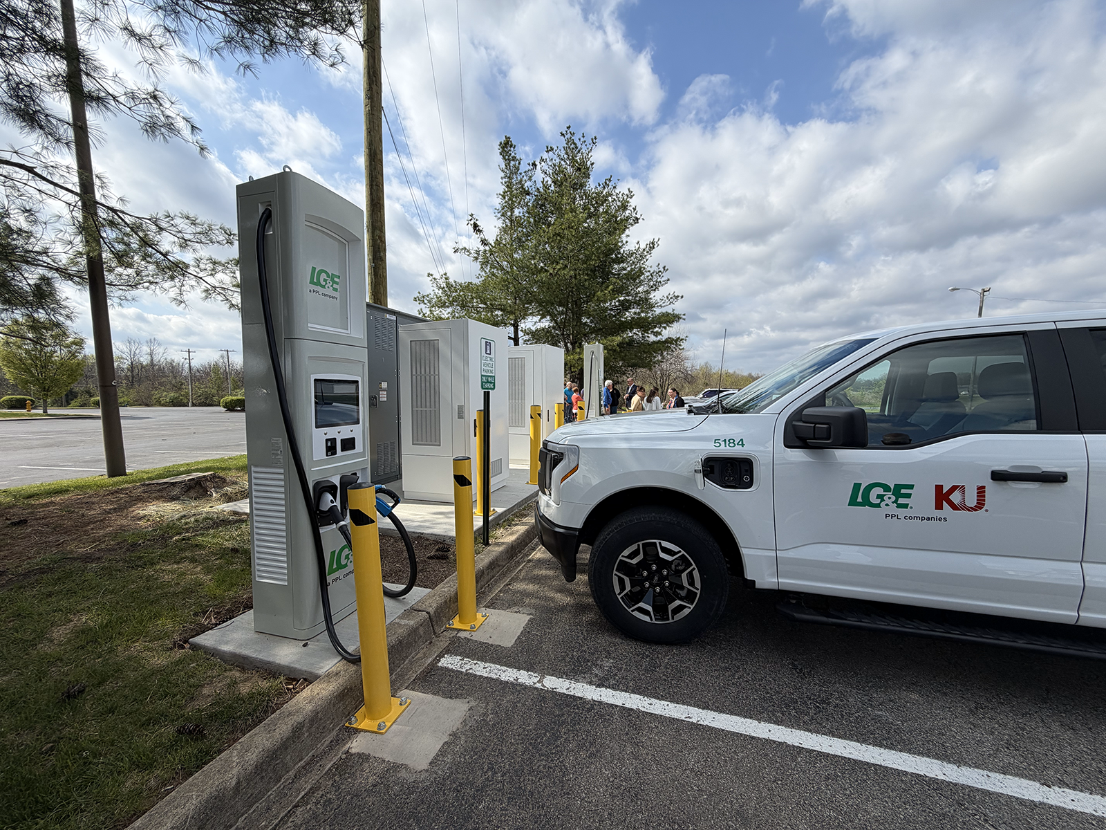 A white EV SUV parked next to an EV charger