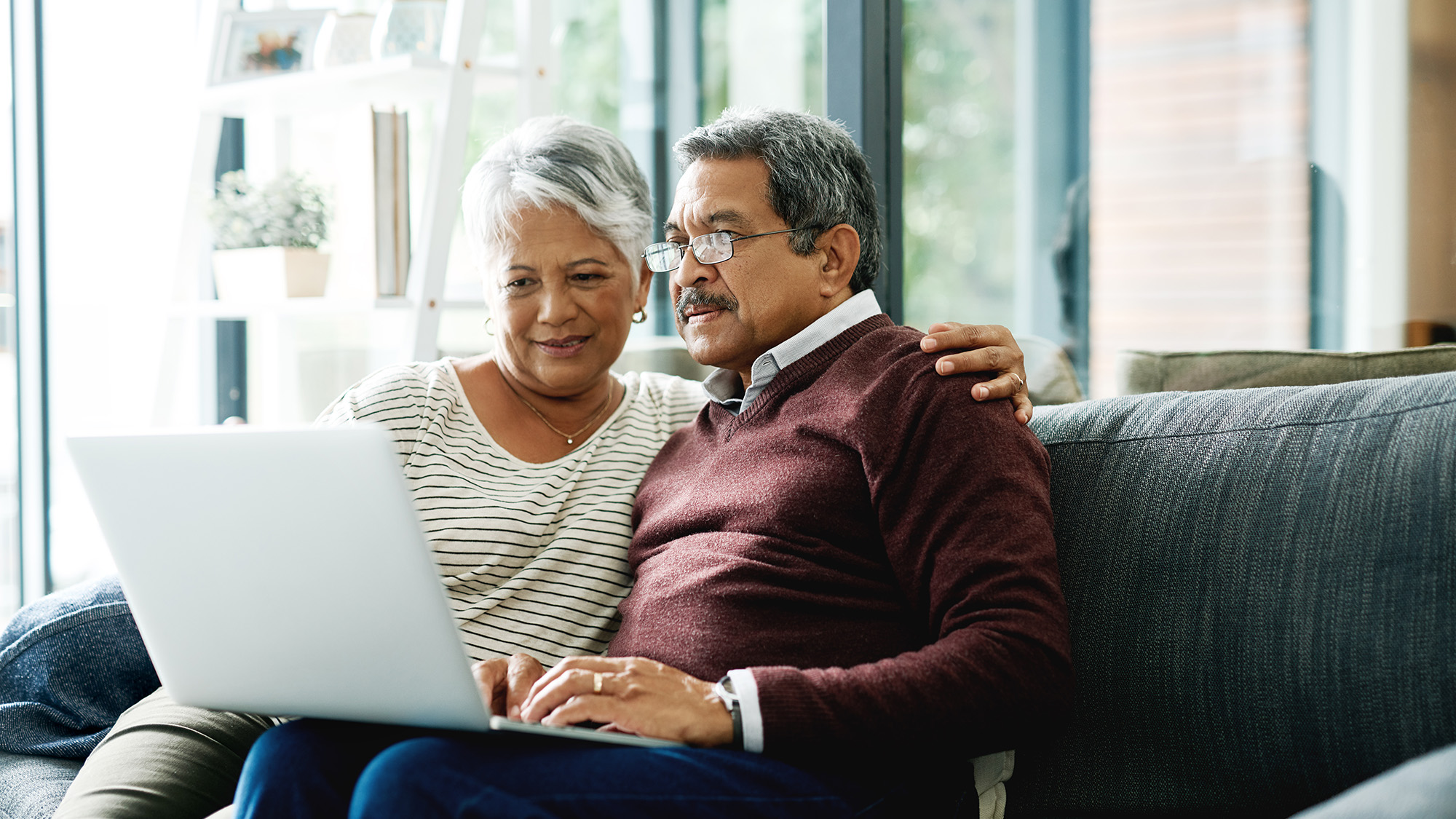 couple on a couch looking at a laptop