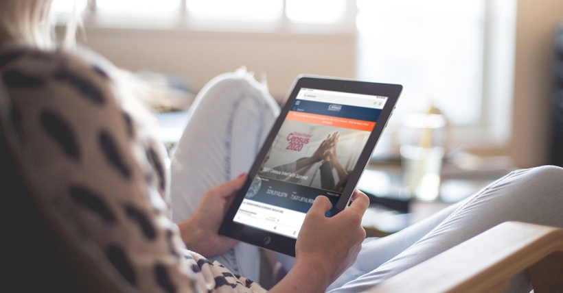 Woman holding iPad with census website on it