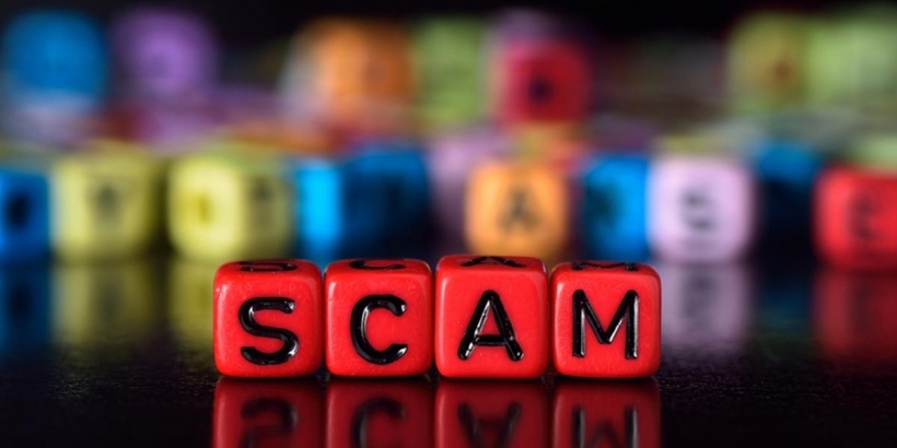 the word scam made up of red bracelet cubes