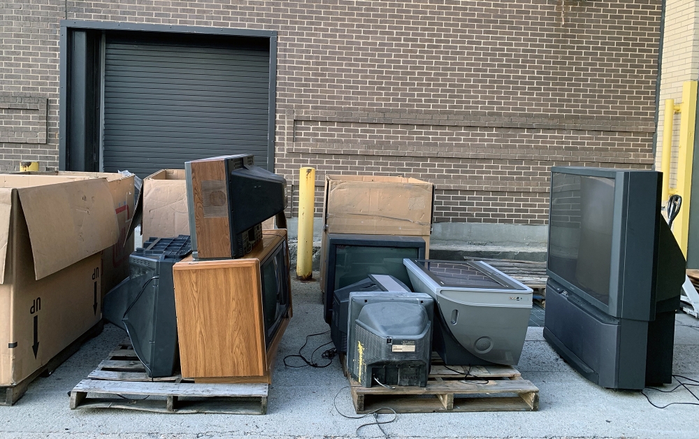 loading dock with pallets full of old electronics for recycling