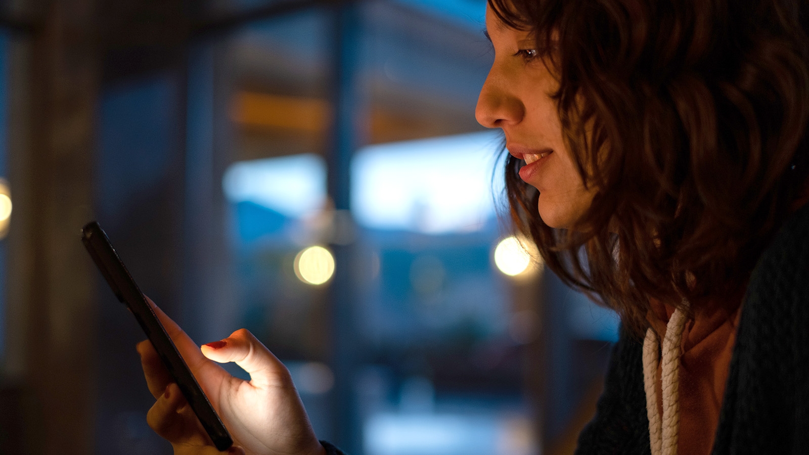 person viewing their mobile phone in the dark