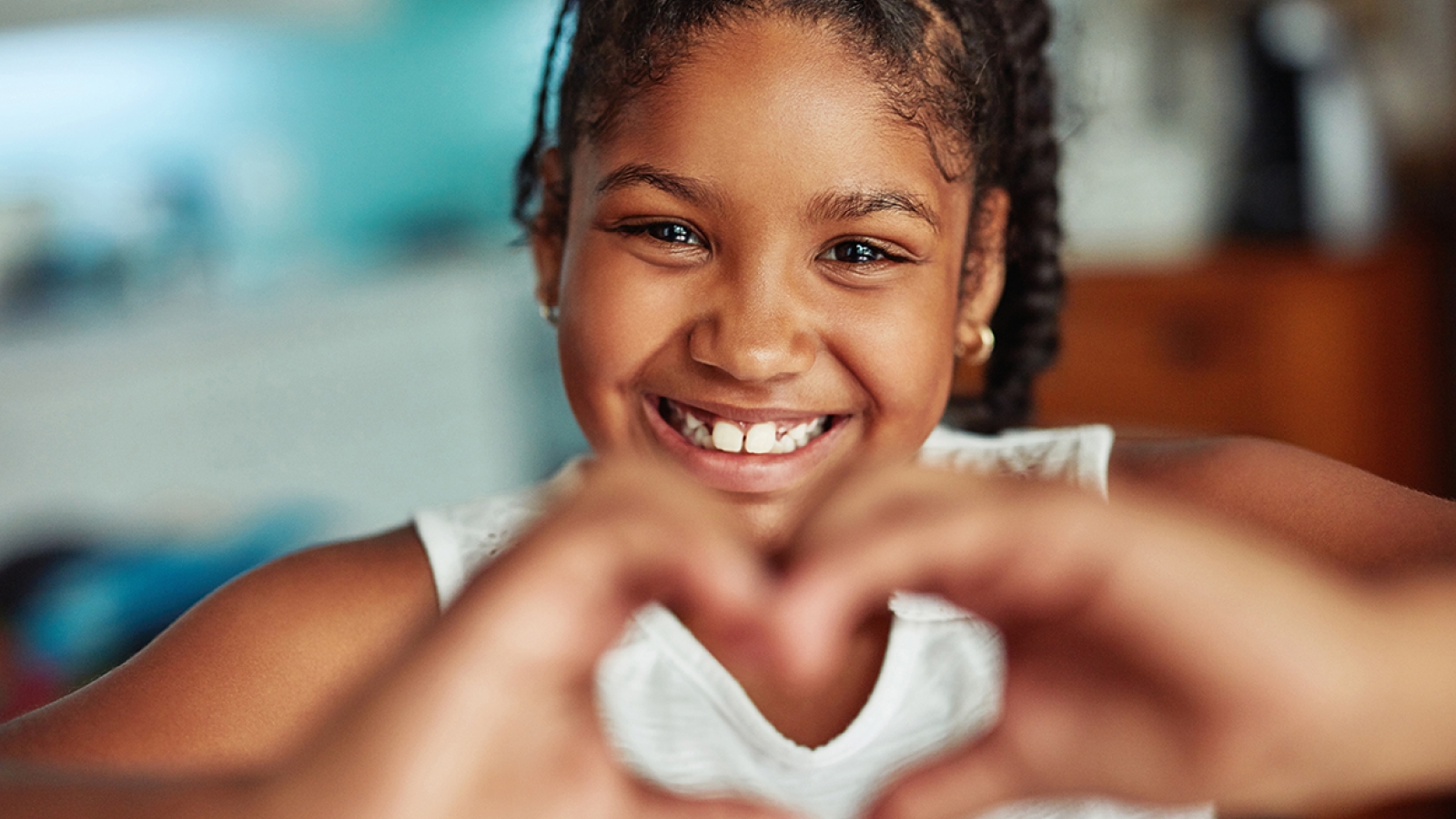 girl holding up heat-shaped hands