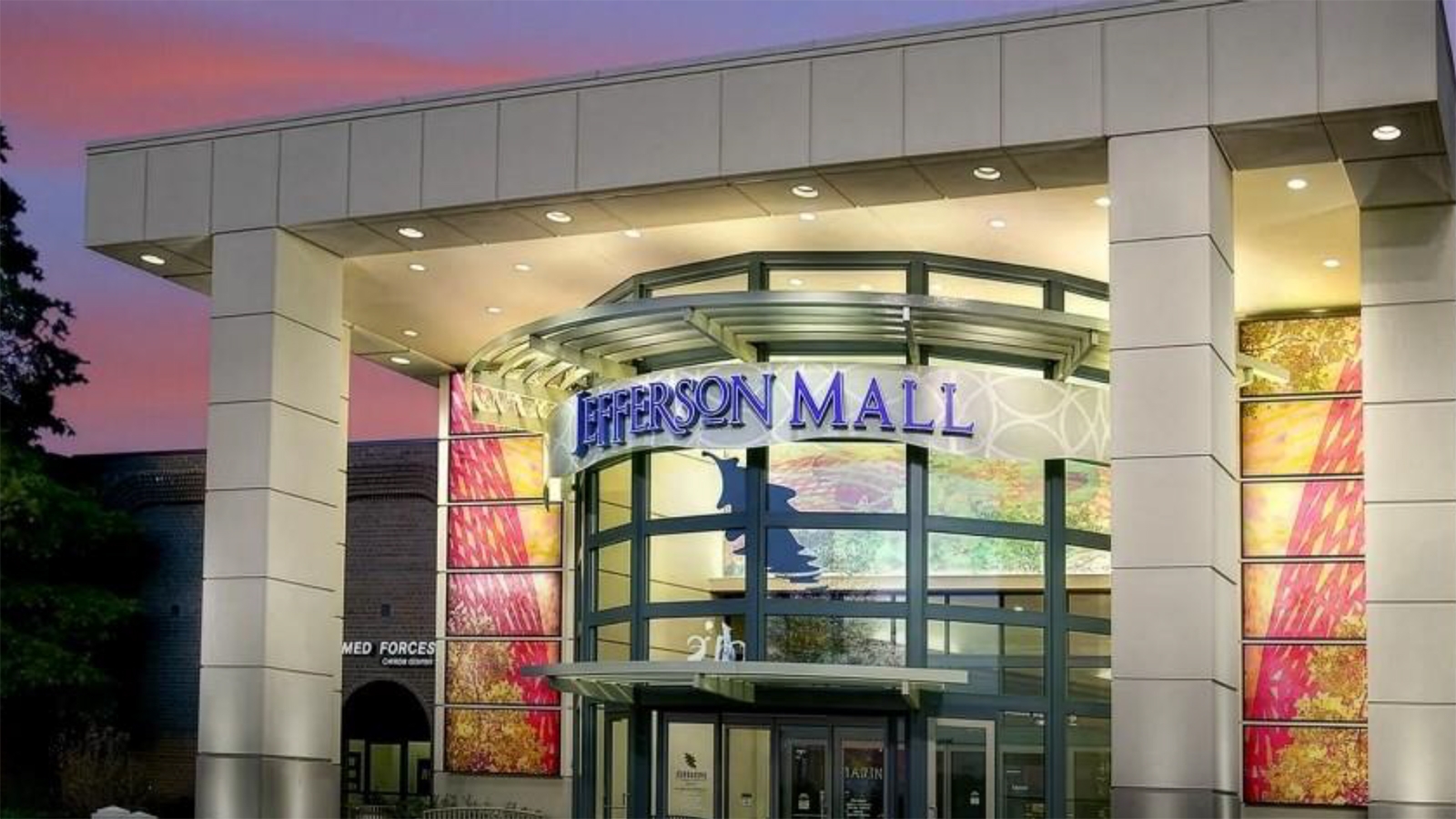 Front entrance of a mall with a twilight background