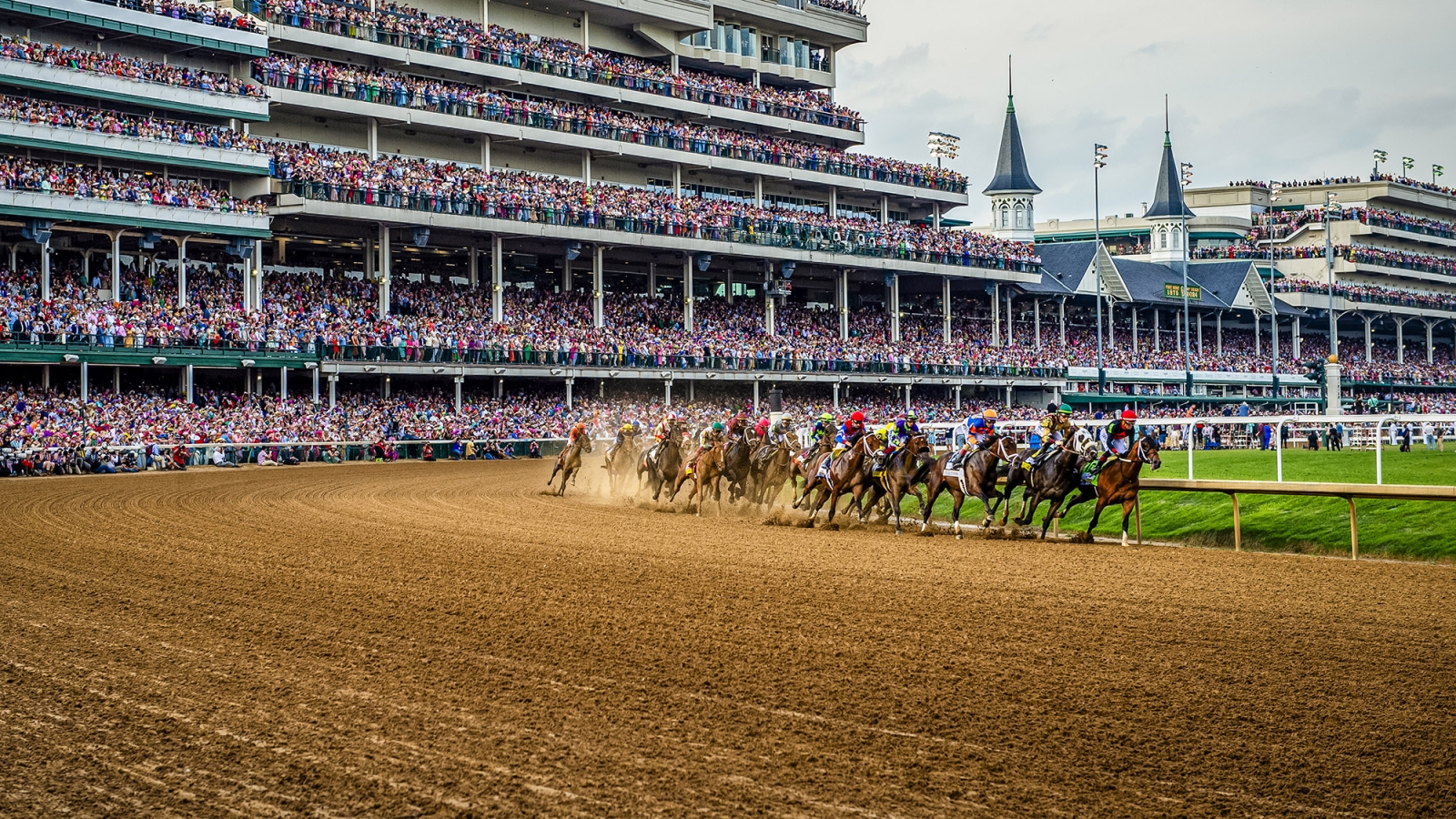 horses running on a dirt track at Churchill Downs during the Kentucky Derby