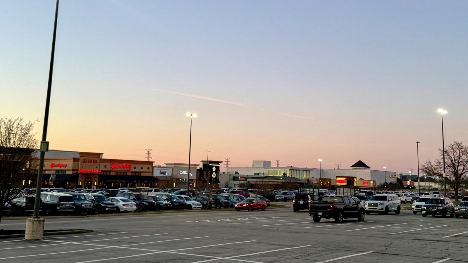 view of a shopping mall from a parking lot at sunset