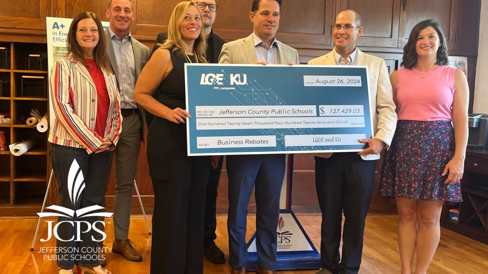 people holding a large check at a presentation