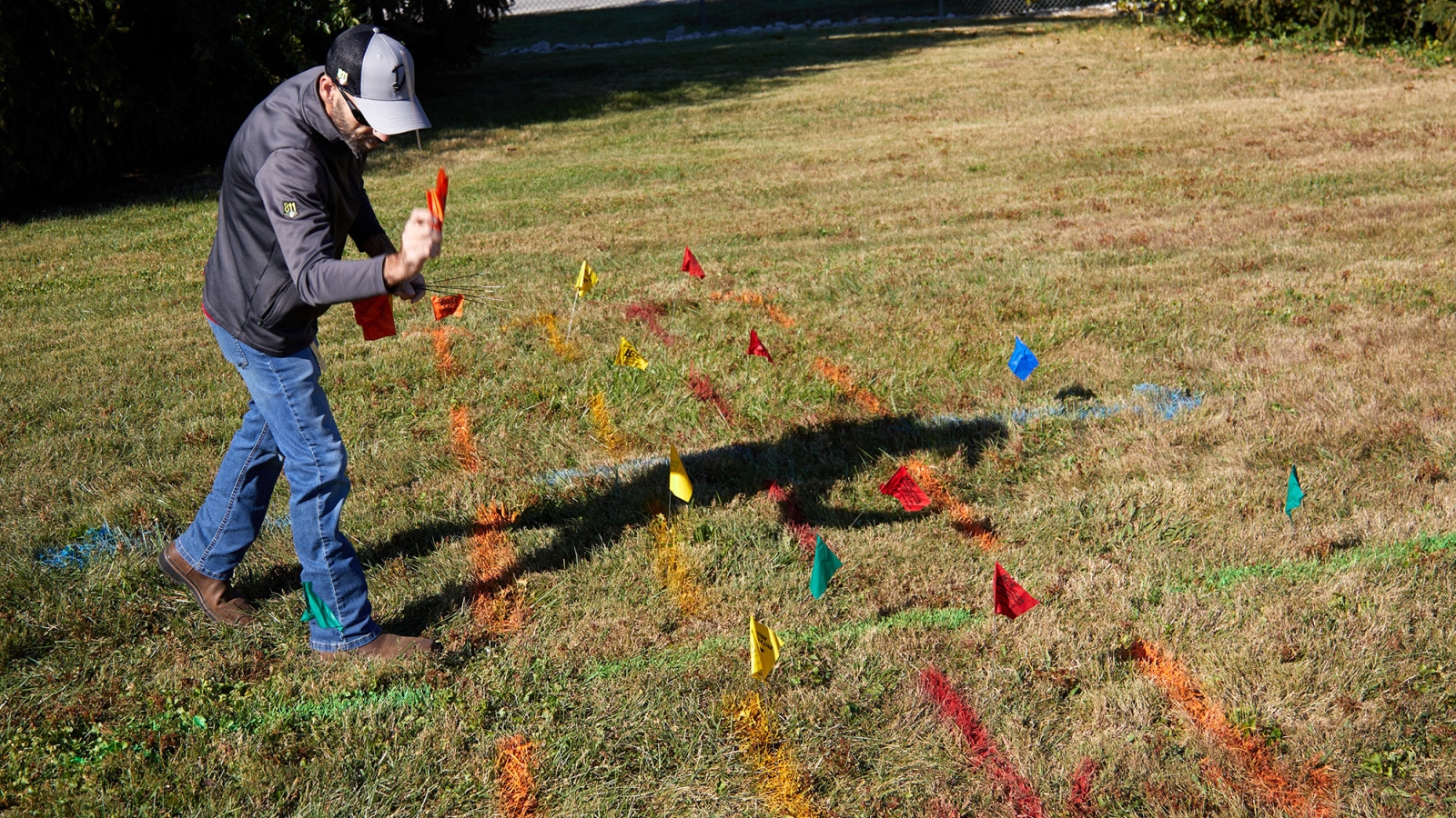 employee marking utility lines in a field