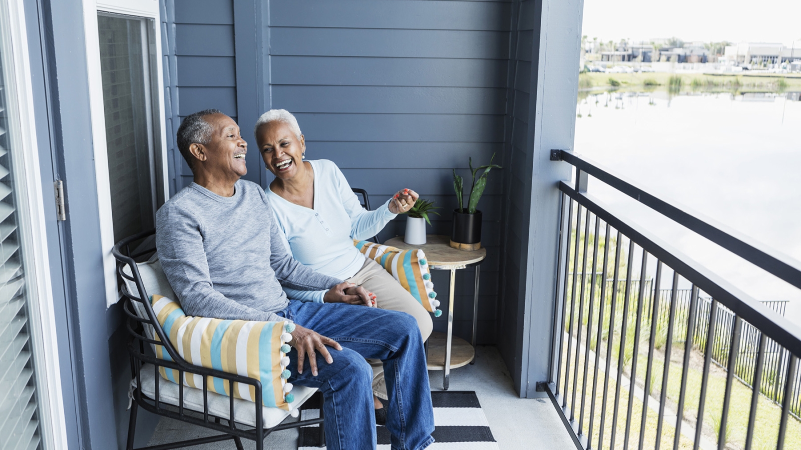 couple sitting on balcony at apartment