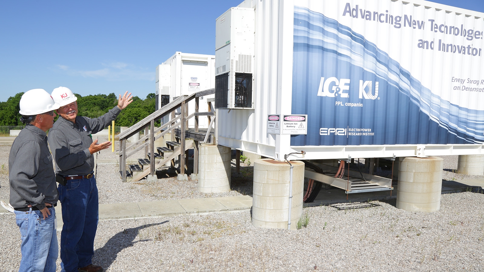 employees next to a battery storage unit