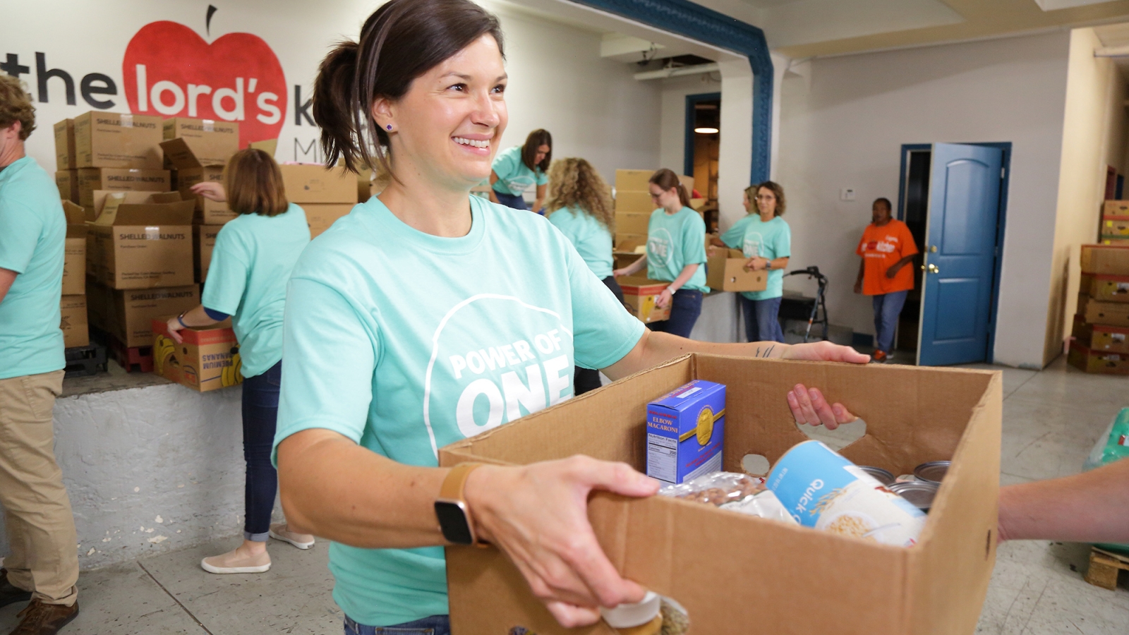 volunteer handing out box of food
