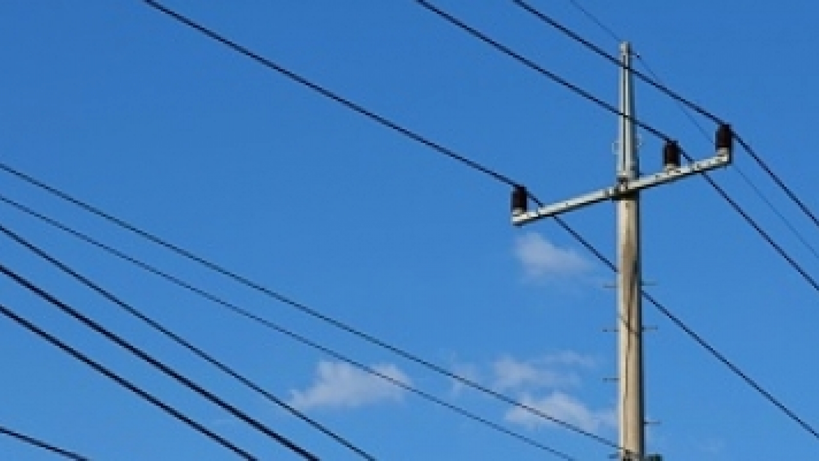 utility pole with power lines against a blue sky