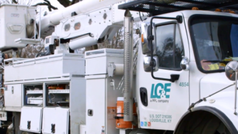 two utility bucket trucks at a location