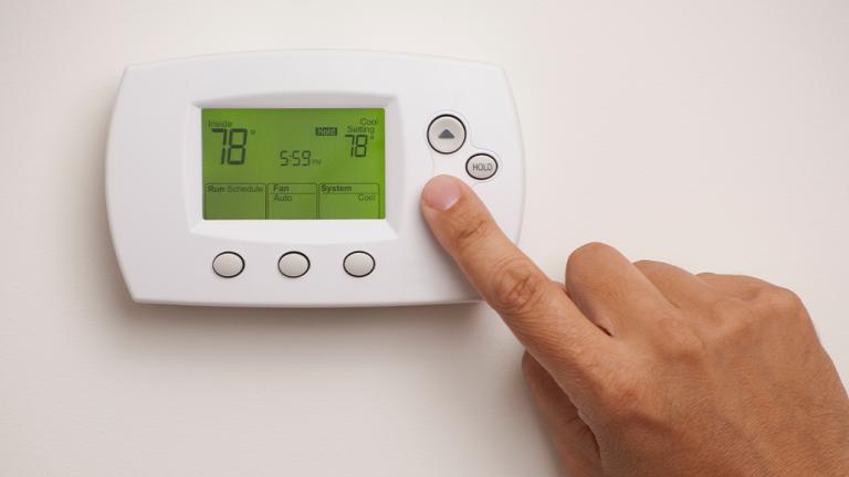Person adjusting thermostat