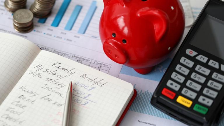 desk with piggy bank, calculator and notepad