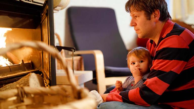 person with child sitting in front of fireplace