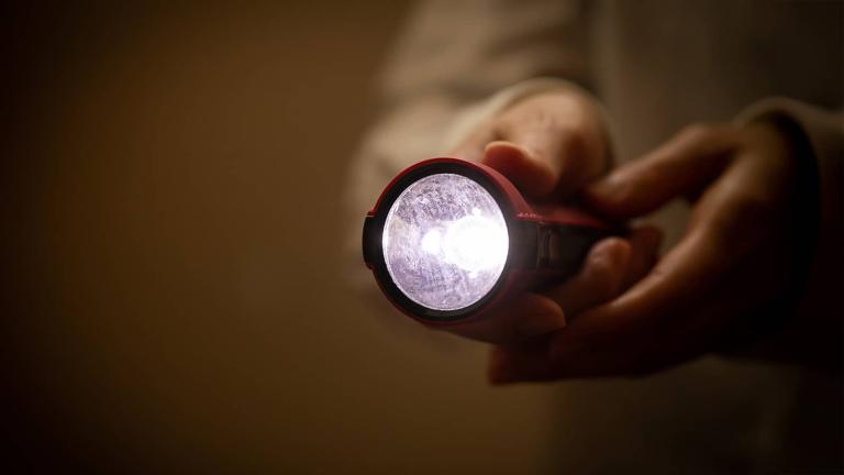 person holding a flashlight in the dark