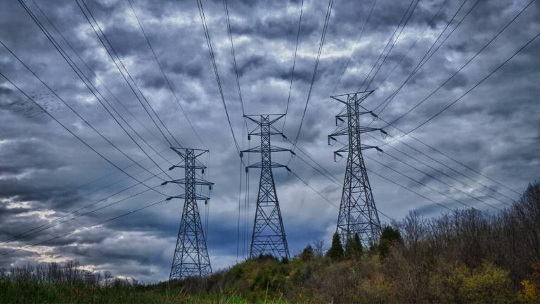 three transmisssion towers under an overcast sky