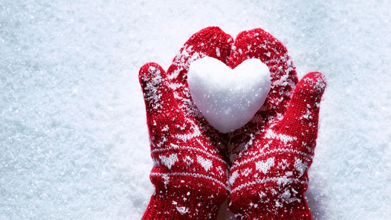 mittens holding a snowball in the shape of a heart
