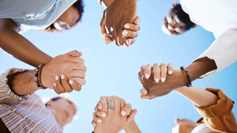 a circle of people holding hands together