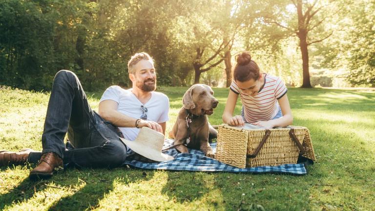 a couple with a dog having a picnic