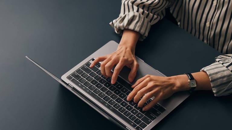 fingers typing on a laptop