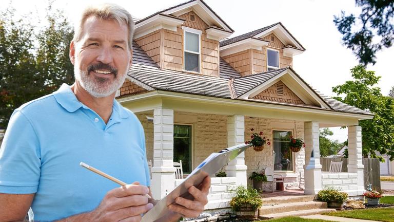 Inspector standing in front of house with clipboard