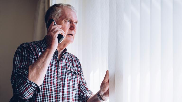 person at window with phone to his ear