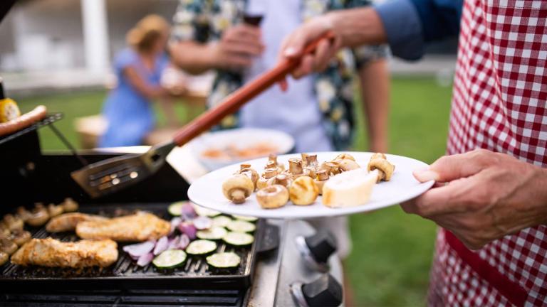 person grilling and holding a plate