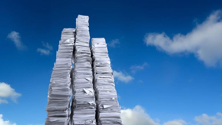 three tall stacks of paper with a blue sky background
