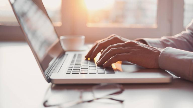 fingers typing on a laptop
