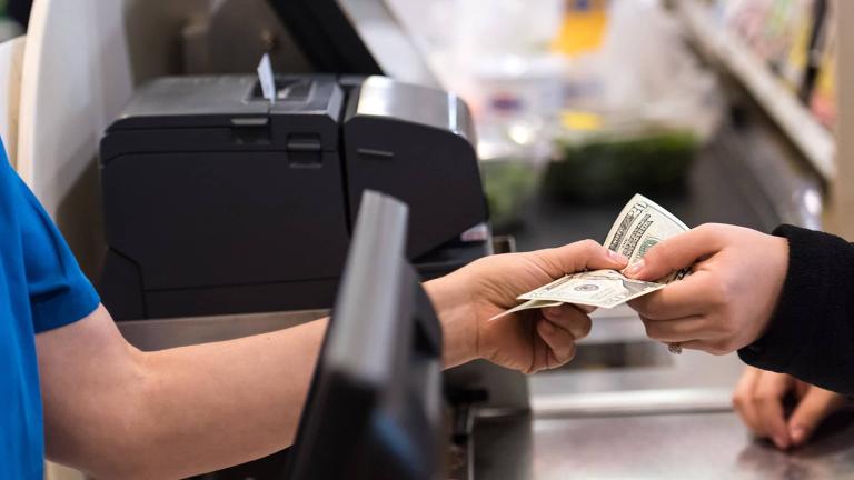 person paying cash at a checkout