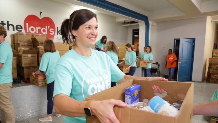 volunteer handing over box of food