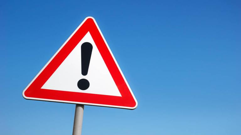 triangular road sign with exclamation point on it