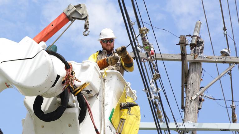 line technician in a bucket truck working on a power line
