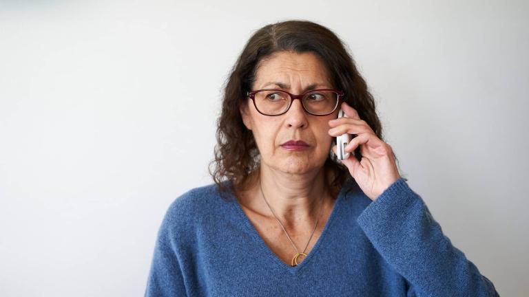 person wearing glasses with phone to ear