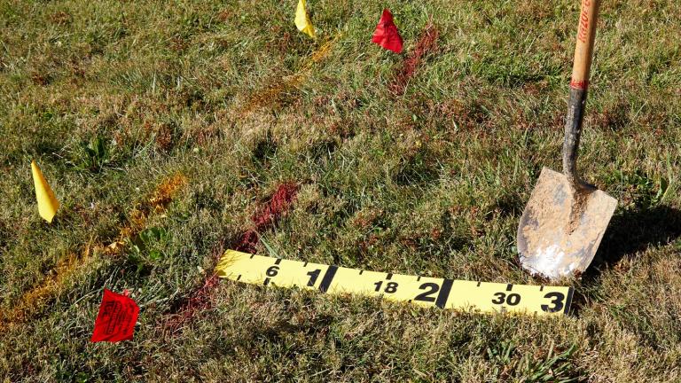 line marking flags and a shovel on a grass yard