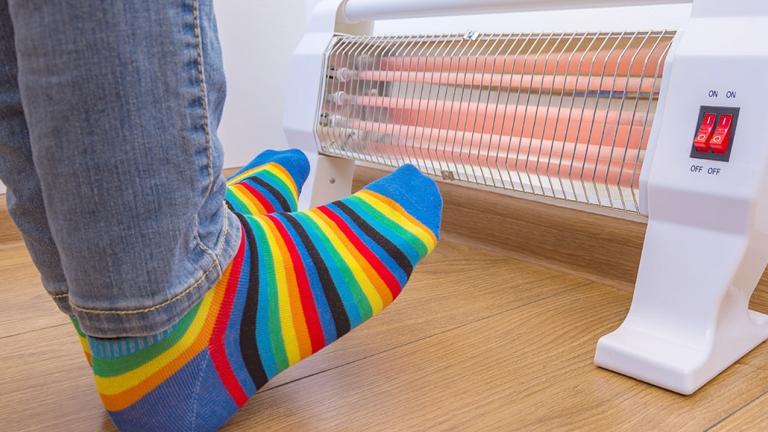 Person warming feet by space heater