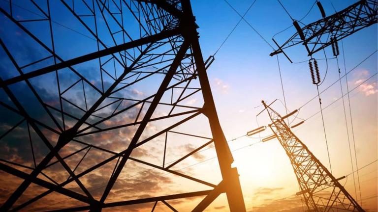 looking up at transmission towers from the ground
